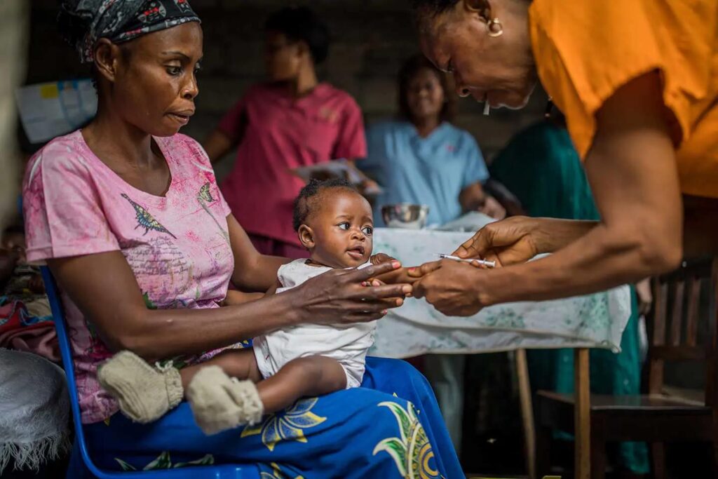 Campagne contre la fièvre jaune au Niger : un enfant assis sur les genoux de sa mère à Diffa